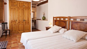 Une chambre avec un grand lit, une armoire en bois et une chaise.