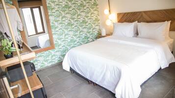 Una cama bien tendida con sábanas blancas, un cabecero de madera y una pared con un diseño de hojas verdes.