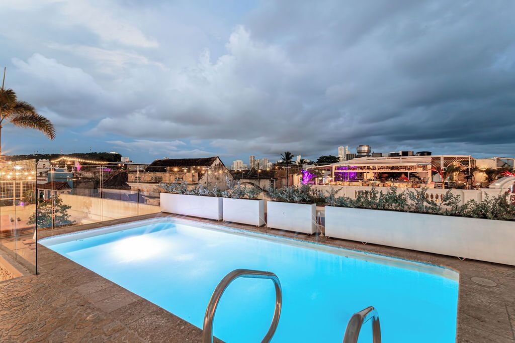 A swimming pool with a clear view of the surrounding area, including buildings and a city skyline in the background.