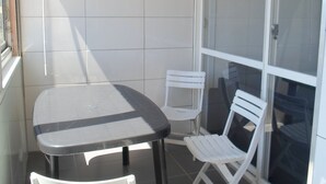 En liten balkong med ett bord och två stolar.