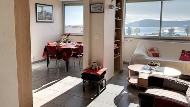 A modern living room with a dining area, a sofa, a small table, and a view of the sea. - Bright apartment in Balaruc-les-Bains, pets allowed (Balaruc-les-Bains)