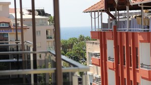 Un edificio de varios pisos con balcones con vistas a la costa.