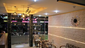 Un interior moderno con una zona de bar, asientos y una pared decorativa.
