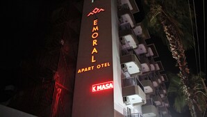 Un edificio con un letrero que dice "EMORAL APART HOTEL" y "K MASA", indicando el nombre del hotel y la marca.
