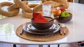 A dining table with a bowl, napkin, spoon, and fruit bowl. - The Exclusive Presidential House (La Quinta)