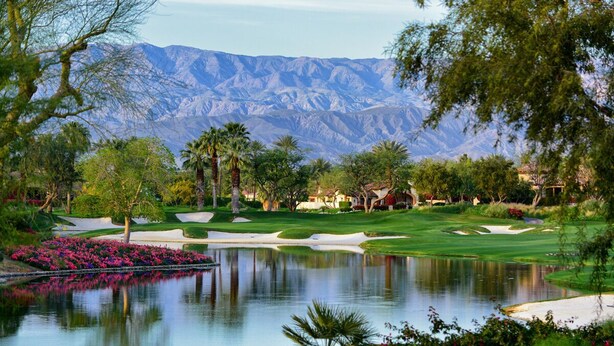 A golf course with a pond, sand bunkers, and a mountain backdrop. - The Exclusive Presidential House (La Quinta)