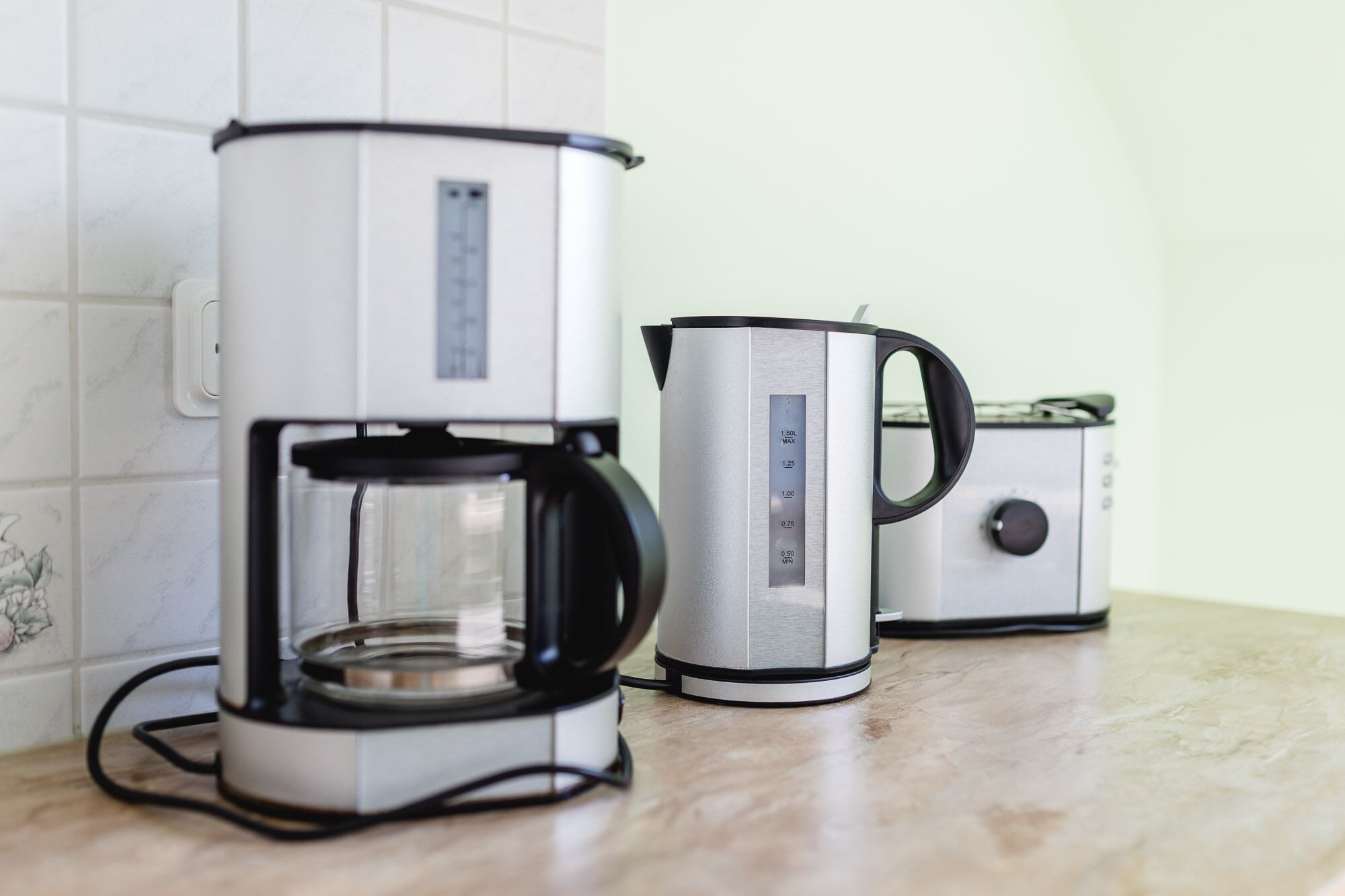 Una cafetera y un tostador sobre la encimera de la cocina.