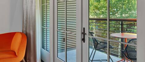 Una habitación con puerta de vidrio corredera que da a un espacio exterior con una mesa y sillas.