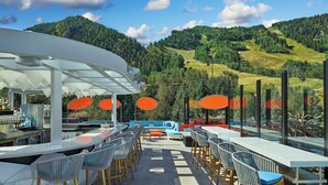 An outdoor bar area with a view of a mountainous landscape. - W Aspen (Aspen)