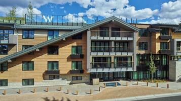 A modern multi-story building with a prominent 'W' logo on the roof, large windows, and a landscaped courtyard.