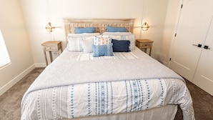 A bedroom with a large bed, two bedside tables, a wooden headboard, and two wall-mounted lamps. - Luxury Zion Escape sleeps 12 *Private Hot Tub* (Washington)