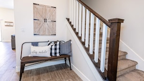 A staircase with wooden railings and a bench with pillows in a hallway. - Luxury Zion Escape sleeps 12 *Private Hot Tub* (Washington)