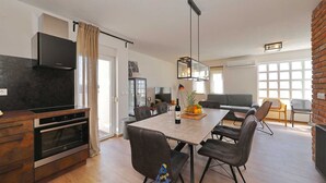Een moderne keuken met een ingebouwde oven en een eethoek met een tafel en stoelen.