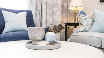 A living room with a round coffee table, a blue sofa, and a grey sofa.