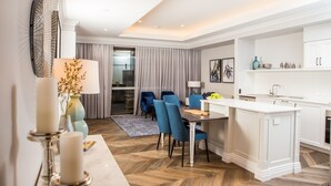 Een moderne hotelkamer met een eethoek, een keuken en een zithoek.