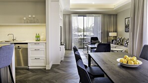 Een moderne hotelkamer met een eethoek, keuken en een balkon met uitzicht.