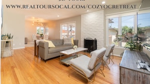 A spacious living room with a grey sofa, a coffee table, and a TV stand.