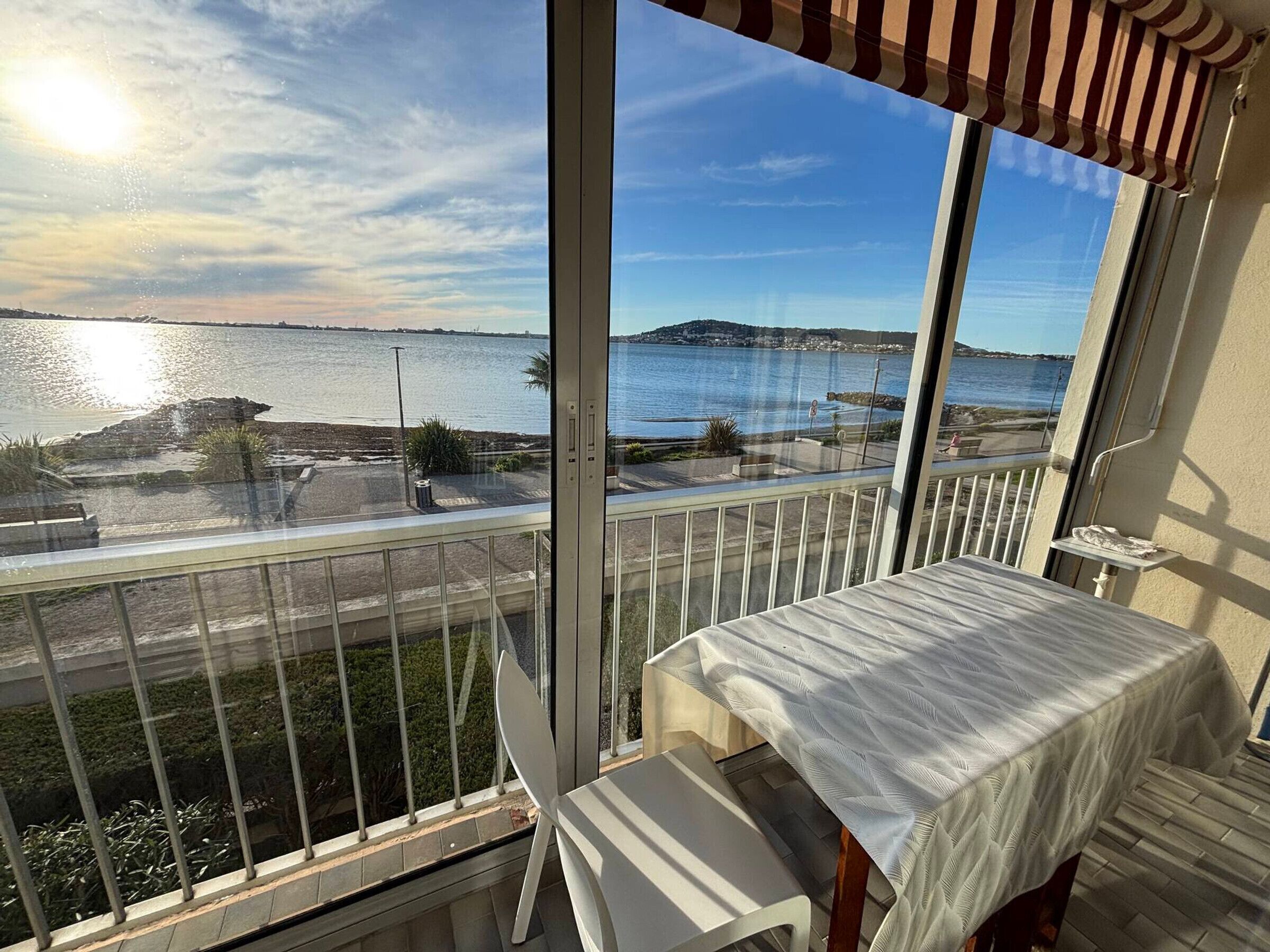 En balkon med udsigt over vand og en fjerndliggende ø.