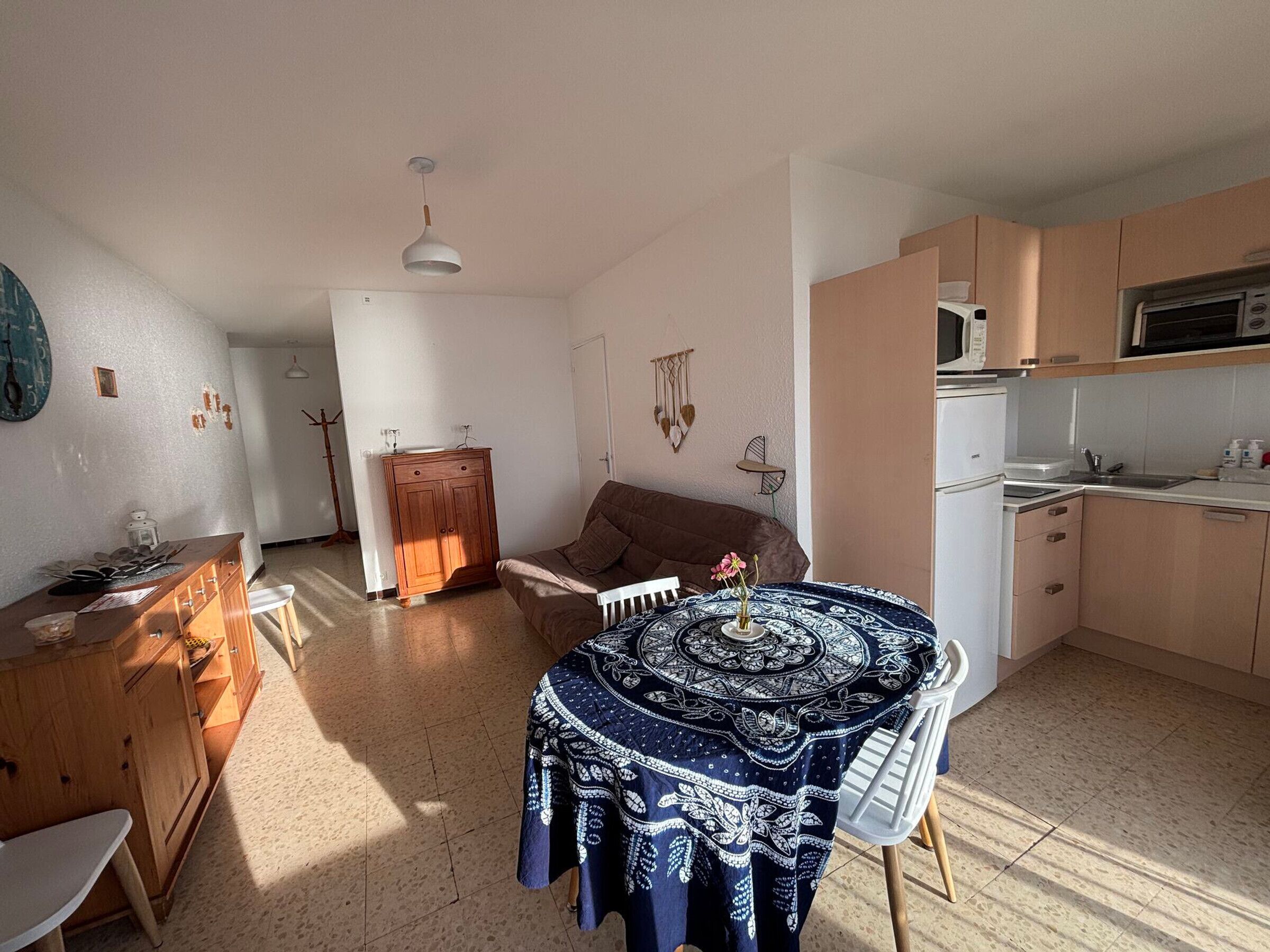 A compact living space with a dining area, a kitchenette, and a sofa.