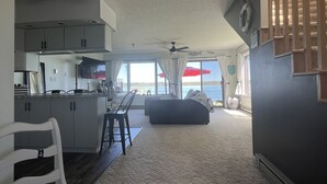 A compact living space with a kitchenette, a dining area, and a large window offering a view of the sea. - Riverside Retreat, sit back and relax...:-) (Sault Ste. Marie)