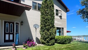 A two-story building with a sloped roof, a satellite dish, and a welcome sign. - Riverside Retreat, sit back and relax...:-) (Sault Ste. Marie)