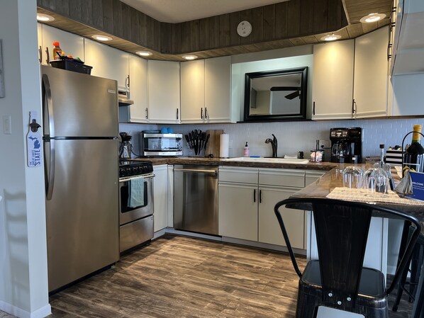 A modern kitchen with stainless steel appliances, a microwave, and a coffee maker.