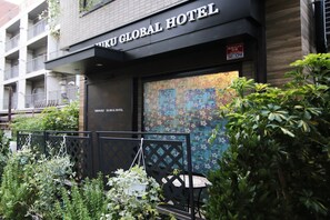 The exterior of the Nikku Global Hotel with a black facade, a visible entrance, and a mosaic window. - Shinjuku Global Hotel (Tokyo)