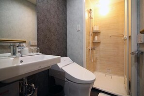 A bathroom with a toilet, sink, and shower.