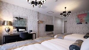 Quarto de hotel com duas camas, uma mesa com luminária, televisão e chuveiro.