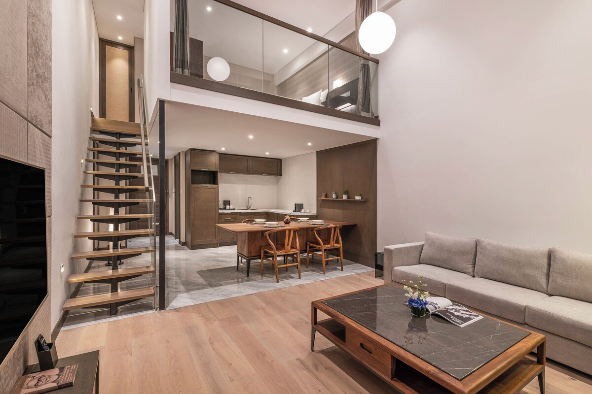 Ein modernes Interieur mit Essbereich, Sofa und Treppe.