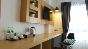 Eine moderne Küche mit Holzausstattung, einem integrierten Fernseher und einem Fenster mit Vorhängen.