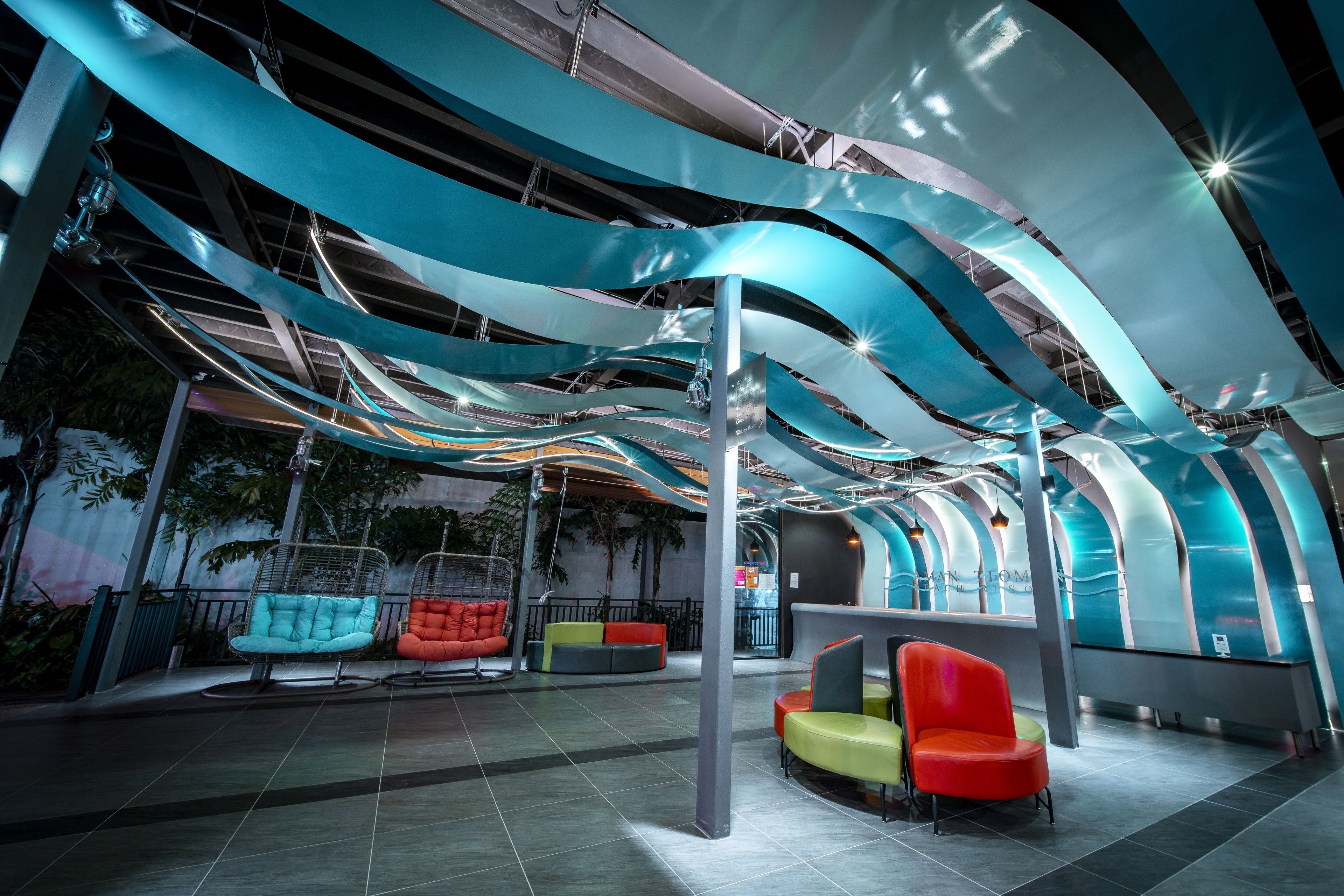 A modern indoor space with curved ceiling structures, seating areas, and a reception desk.