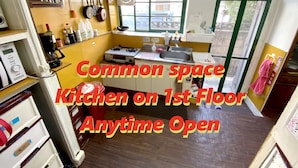 A compact kitchen with a gas stove, sink, and various kitchen utensils. It is located on the first floor and is open at all times. - Guesthouse Base Okinawa - Hostel (Naha)