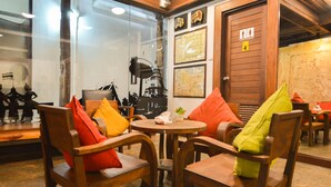 Une pièce chaleureuse, meublée de meubles en bois, avec une table ronde et une porte portant des panneaux d’accessibilité.