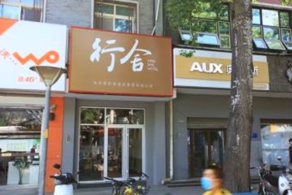 A hotel facade with signage for 'WOO' and 'AUX'.