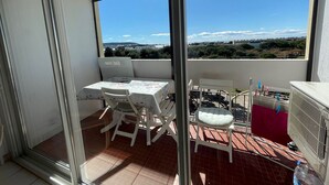 A balcony with a table and chairs, a view of the landscape, and a radiator. - Cozy apartment with balcony, pets allowed, for holidays or treatments (Balaruc-les-Bains)
