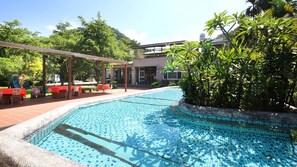 A swimming pool with a tiled edge, surrounded by a covered patio area with tables and chairs. - Erping Mountain Resort (Shuili)