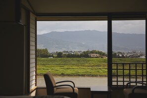 Una habitación con vista a un río y montañas.