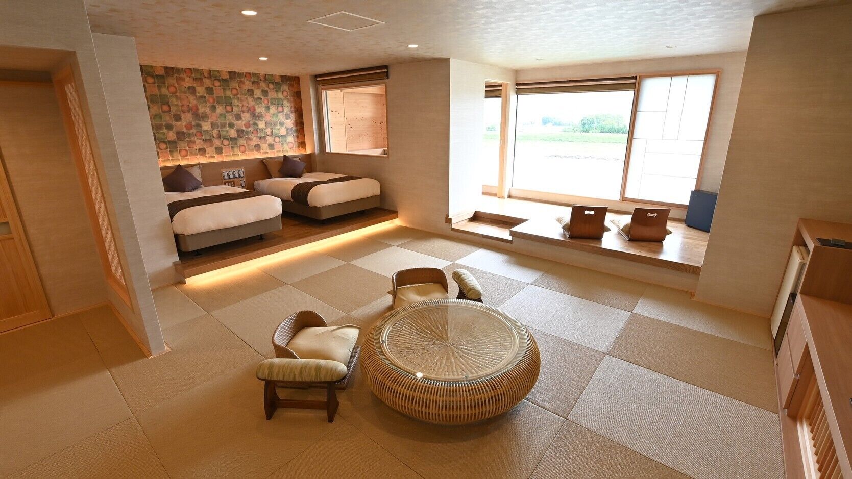 Una habitación amplia con una cama grande, una mesa de comedor y una zona de estar.