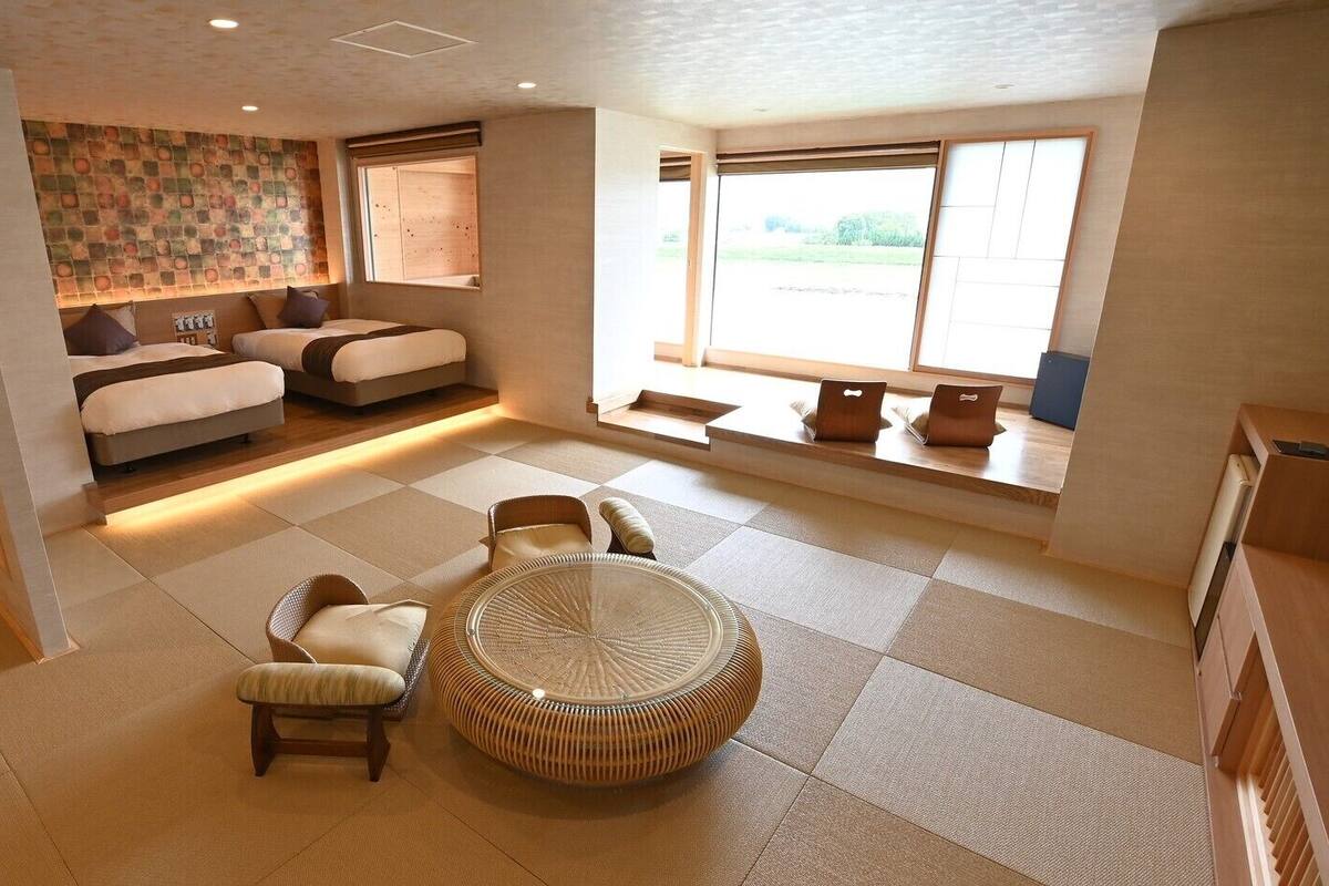 Una habitación amplia con una cama grande, una mesa de comedor y una zona de estar.