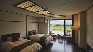 Une chambre d’hôtel avec deux lits, une grande fenêtre et une vue sur l’extérieur.