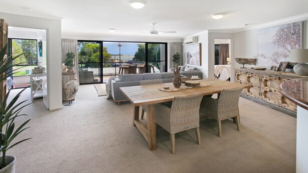 Un espacio habitable amplio con una mesa de comedor, sofás y vistas al exterior.
