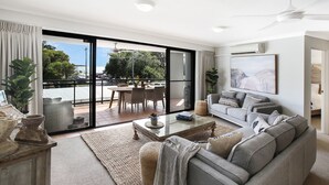 Un salón amplio con un gran ventanal corredizo que da a un patio exterior.