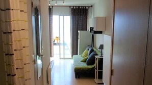 A hotel room with a bed, a nightstand, a lamp, and a view of the outdoors through a sliding door. - Air-conditioned apartment near the Thermal Baths in Balaruc-les-Bains (Balaruc-les-Bains)