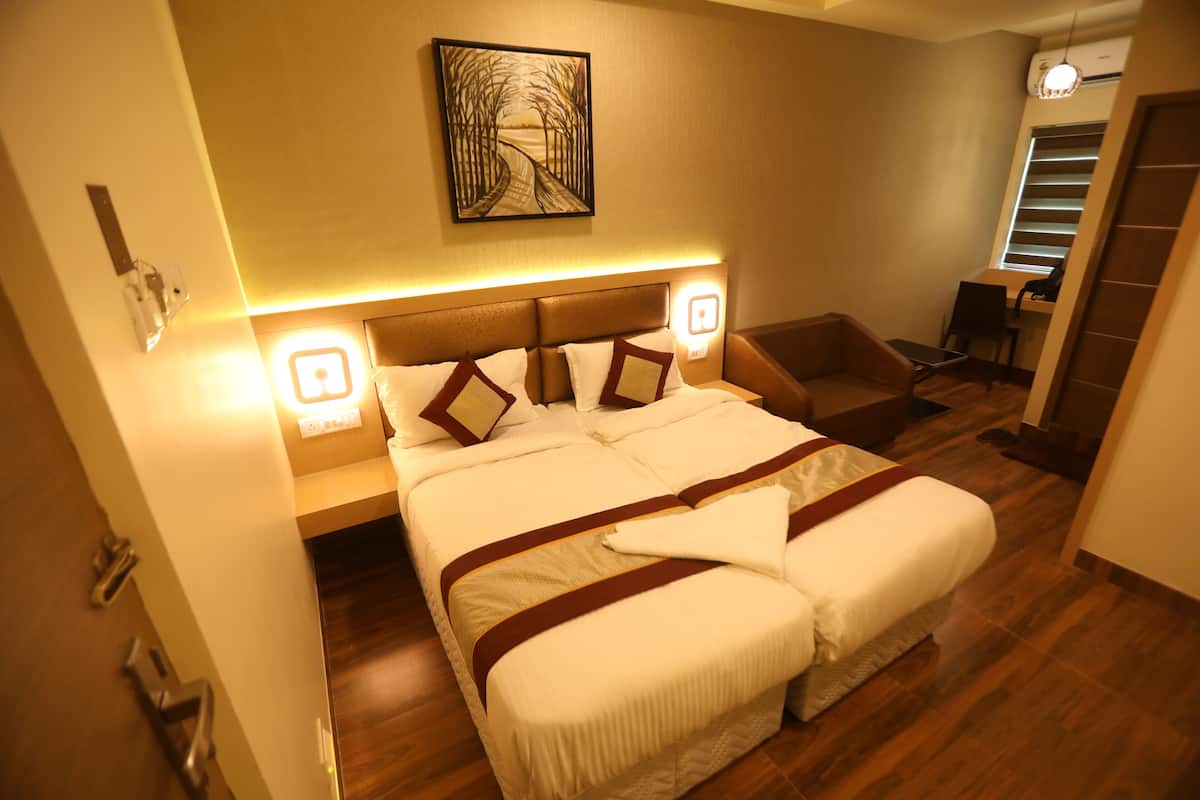 A hotel room with a large bed, bedside tables, a desk, and a chair.