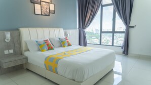 A modern hotel room with a large bed, a nightstand, a window with curtains, and a city view. - OYO Home 43995 Premium 3br 1tebrau (Johor Bahru)