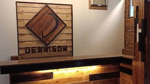 A reception desk with a wooden panel design and the name "DEWIMSON" displayed above it. - The Dennison Hotel (Angeles City)