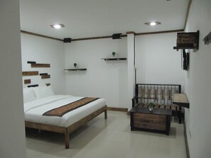 A bedroom with a bed, bedside table, and a small desk with a chair. - The Dennison Hotel (Angeles City)