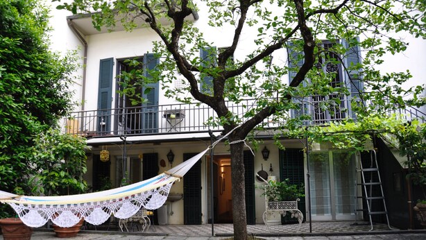 A courtyard with a hammock, a tree, and a building with a balcony. - Nearby Fortress and close to the center, patio and garden (Firenze)