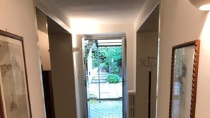 A hallway with a patterned rug, a framed picture on the left, and a door leading outside. - Nearby Fortress and close to the center, patio and garden (Firenze)
